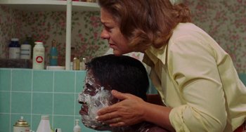 Movie still from “Watermelon Man” (1970), directed by Melvin Van Peebles – A woman is shaving a man's face with foil; Close Up shot, Over the shoulder angle