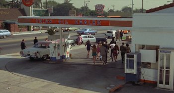 Movie still from “Watermelon Man” (1970), directed by Melvin Van Peebles – A group of people walking down a street; Extreme Wide shot, High angle