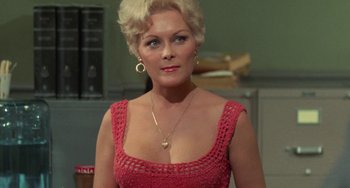 Movie still from “Watermelon Man” (1970), directed by Melvin Van Peebles – A woman with blonde hair wearing a red dress; Close Up shot, Over the shoulder angle