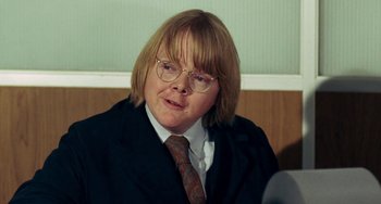 Movie still from “Watermelon Man” (1970), directed by Melvin Van Peebles – A woman with blonde hair wearing a suit and tie; Close Up shot, Over the shoulder angle