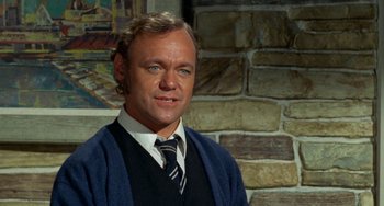 Movie still from “Watermelon Man” (1970), directed by Melvin Van Peebles – A person wearing a suit and tie; Close Up shot, High angle