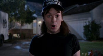 Movie still from “Wayne's World” (1992), directed by Penelope Spheeris – A person with a hat and a surprised look on their face; Medium shot, Overhead angle