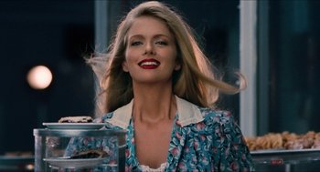 Movie still from “Wayne's World” (1992), directed by Penelope Spheeris – A woman with long blonde hair is smiling for the camera; Close Up shot, Low angle