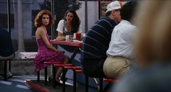 Movie still from “Wayne's World” (1992), directed by Penelope Spheeris – A group of people sitting at a table with drinks; Wide shot, Over the shoulder angle