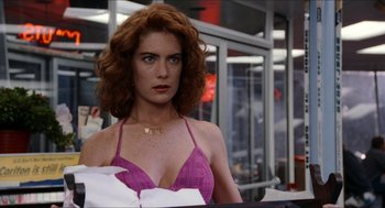 Movie still from “Wayne's World” (1992), directed by Penelope Spheeris – A woman with red hair and a purple bikini top; Close Up shot, Over the shoulder angle