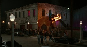 Movie still from “Wayne's World” (1992), directed by Penelope Spheeris – A group of people walking down a street at night; Extreme Wide shot, High angle