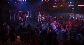 Movie still from “Wayne's World” (1992), directed by Penelope Spheeris – A group of people sitting in front of an audience; Wide shot, High angle