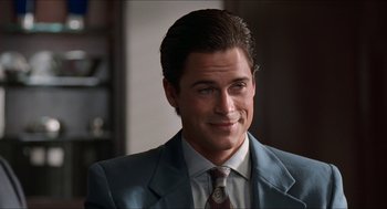 Movie still from “Wayne's World” (1992), directed by Penelope Spheeris – A person wearing a suit and tie; Close Up shot, Over the shoulder angle