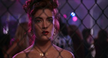 Movie still from “Wayne's World” (1992), directed by Penelope Spheeris – A beautiful woman with red hair wearing a necklace; Close Up shot, Over the shoulder angle