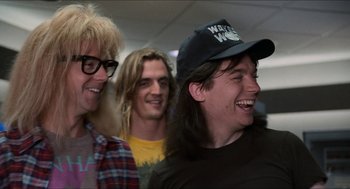 Movie still from “Wayne's World” (1992), directed by Penelope Spheeris – A group of young men standing next to each other; Medium shot, Low angle