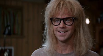 Movie still from “Wayne's World” (1992), directed by Penelope Spheeris – A man with long blonde hair wearing glasses; Close Up shot, Over the shoulder angle