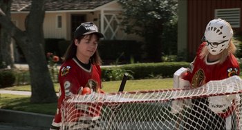 Movie still from “Wayne's World” (1992), directed by Penelope Spheeris – A woman in a hockey uniform is playing a game; Medium shot, High angle