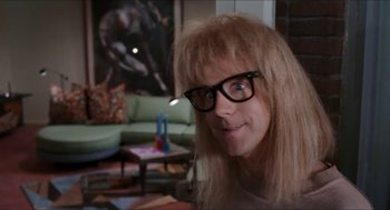Movie still from “Wayne's World” (1992), directed by Penelope Spheeris – A woman with long blonde hair wearing glasses; Close Up shot, Over the shoulder angle