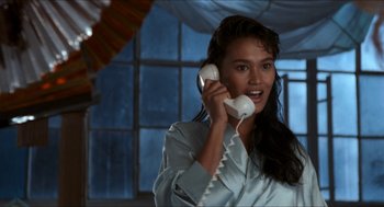 Movie still from “Wayne's World” (1992), directed by Penelope Spheeris – A woman holding a phone up to her ear; Close Up shot, Low angle