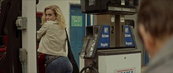 Movie still from “We Summon the Darkness” (2019), directed by Marc Meyers – A woman standing next to a gas pump in a gas station; Medium shot, Over the shoulder angle