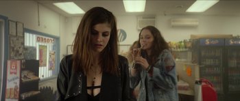 Movie still from “We Summon the Darkness” (2019), directed by Marc Meyers – A woman in a leather jacket is looking down at her face; Medium shot, Over the shoulder angle