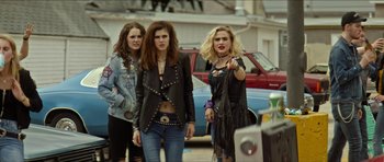 Movie still from “We Summon the Darkness” (2019), directed by Marc Meyers – A group of young women standing next to each other on the street; Medium shot, Over the shoulder angle