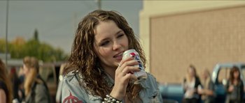 Movie still from “We Summon the Darkness” (2019), directed by Marc Meyers – A woman holding a can of beer in her hand; Close Up shot, Over the shoulder angle