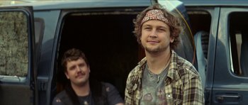 Movie still from “We Summon the Darkness” (2019), directed by Marc Meyers – A man with a bandana around his head and a man with a beard; Close Up shot, Low angle