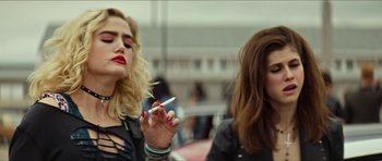 Movie still from “We Summon the Darkness” (2019), directed by Marc Meyers – Two women are smoking a cigarette in a room; Close Up shot, Over the shoulder angle