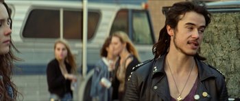 Movie still from “We Summon the Darkness” (2019), directed by Marc Meyers – A group of people walking down a street; Close Up shot, Over the shoulder angle