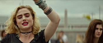 Movie still from “We Summon the Darkness” (2019), directed by Marc Meyers – A person wearing a black shirt; Close Up shot, Over the shoulder angle