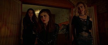 Movie still from “We Summon the Darkness” (2019), directed by Marc Meyers – A group of people standing in a room; Medium shot, Low angle