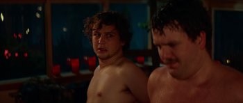 Movie still from “We Summon the Darkness” (2019), directed by Marc Meyers – A man in a towel standing next to another man in a bath tub; Close Up shot, Over the shoulder angle