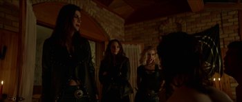 Movie still from “We Summon the Darkness” (2019), directed by Marc Meyers – A group of women standing next to each other in a room; Medium shot, Over the shoulder angle