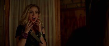 Movie still from “We Summon the Darkness” (2019), directed by Marc Meyers – A woman with a knife in her mouth; Close Up shot, Over the shoulder angle