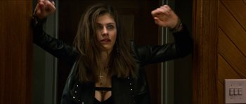 Movie still from “We Summon the Darkness” (2019), directed by Marc Meyers – A woman in a black leather jacket with a cross on her chest; Close Up shot, Over the shoulder angle