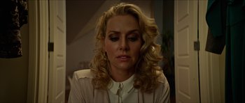 Movie still from “We Summon the Darkness” (2019), directed by Marc Meyers – A woman with blonde curly hair wearing a white shirt; Close Up shot, Low angle