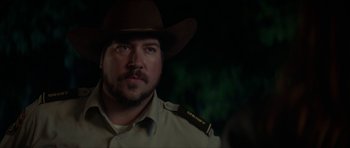 Movie still from “We Summon the Darkness” (2019), directed by Marc Meyers – A person wearing a cowboy hat; Close Up shot, Over the shoulder angle