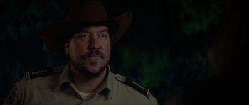 Movie still from “We Summon the Darkness” (2019), directed by Marc Meyers – A person wearing a cowboy hat; Close Up shot, Over the shoulder angle