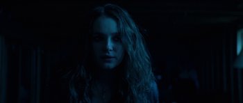 Movie still from “We Summon the Darkness” (2019), directed by Marc Meyers – A woman with long hair is in the dark; Close Up shot, Over the shoulder angle