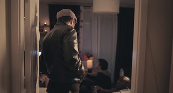 Movie still from “Weekend” (2011), directed by Andrew Haigh – A group of people sitting in a living room; Medium shot, Over the shoulder angle
