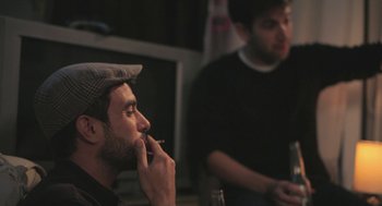 Movie still from “Weekend” (2011), directed by Andrew Haigh – Two men sitting in front of each other; Medium shot, Over the shoulder angle