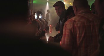 Movie still from “Weekend” (2011), directed by Andrew Haigh – A man sitting at a bar in a pub; Medium shot, Over the shoulder angle