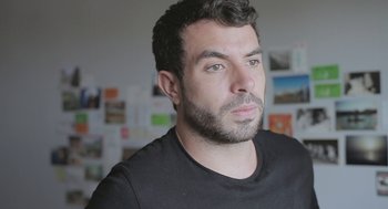 Movie still from “Weekend” (2011), directed by Andrew Haigh – A person wearing a black t - shirt; Close Up shot, Low angle