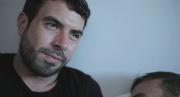 Movie still from “Weekend” (2011), directed by Andrew Haigh – A person wearing a black shirt; Close Up shot, Over the shoulder angle