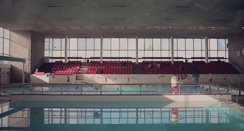 Movie still from “Weekend” (2011), directed by Andrew Haigh – A man standing in a pool next to an empty swimming pool; Extreme Wide shot, Low angle