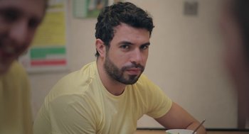 Movie still from “Weekend” (2011), directed by Andrew Haigh – A person sitting at a table; Close Up shot, Over the shoulder angle