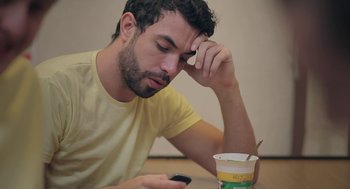 Movie still from “Weekend” (2011), directed by Andrew Haigh – A man sitting at a table with a cup of coffee; Close Up shot, High angle