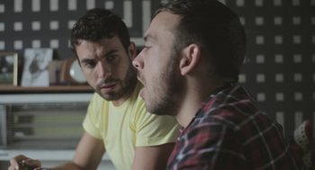 Movie still from “Weekend” (2011), directed by Andrew Haigh – Two men are sitting in front of each other; Close Up shot, Over the shoulder angle