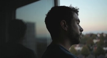 Movie still from “Weekend” (2011), directed by Andrew Haigh – A person looking out of a window; Close Up shot, Low angle