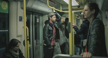 Movie still from “Weekend” (2011), directed by Andrew Haigh – A group of people riding on a train; Medium shot, Over the shoulder angle