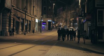 Movie still from “Weekend” (2011), directed by Andrew Haigh – A group of people walking down a street at night; Extreme Wide shot, High angle