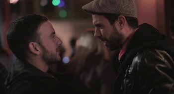 Movie still from “Weekend” (2011), directed by Andrew Haigh – Two men talking to each other at a party; Close Up shot, Over the shoulder angle