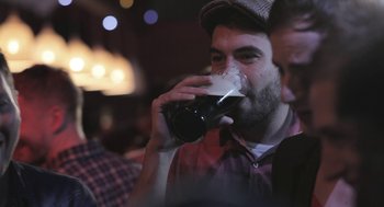 Movie still from “Weekend” (2011), directed by Andrew Haigh – A man drinking a beer at a bar; Close Up shot, Over the shoulder angle