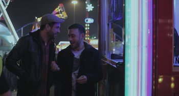 Movie still from “Weekend” (2011), directed by Andrew Haigh – Two men standing next to each other on a street; Medium shot, Over the shoulder angle